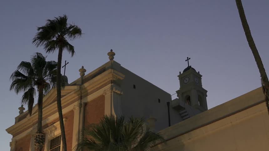 A building has crosses on it at sunset