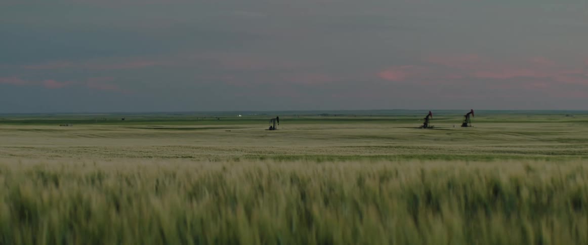 Oil pumps on an oilfield in the countryside in the evening