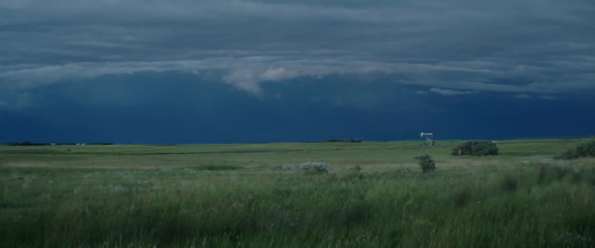 Storm clouds move over a rural area and lightning flashes in the dark sky