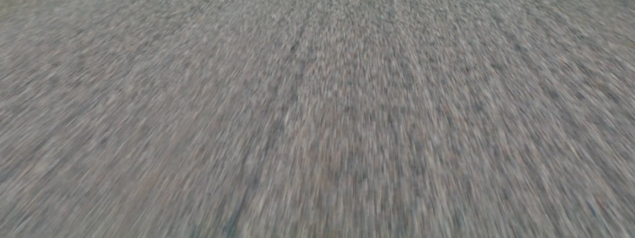 Texture of passing gravel road from moving vehicle