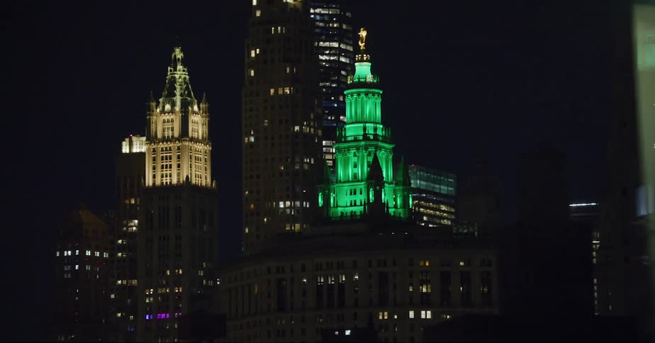 New york city buildings lit green glowing in the night sky