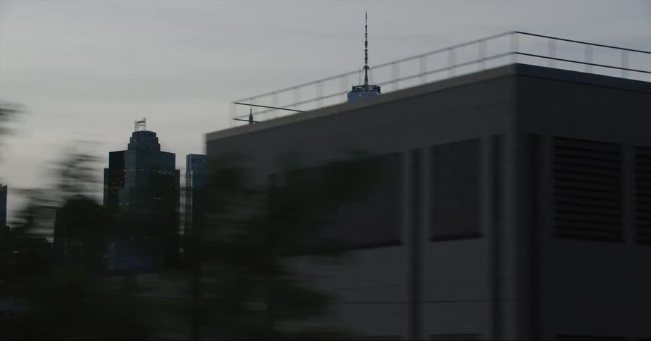 Traveling past the new york city skyline with one world trade center spire above them all