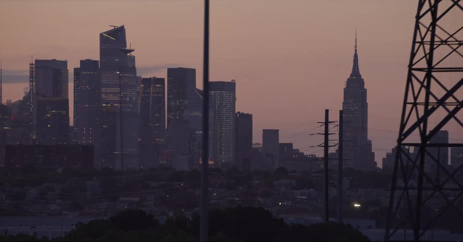 Downtown skyscrapers are partially silhouetted against red sky
