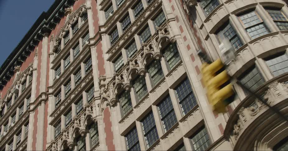 A tall building with intricate architecture has cornices and old windows