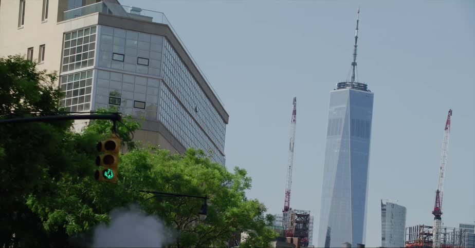 The one world trade center tower standing between two construction cranes