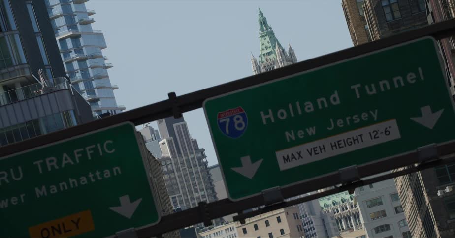 Traffic signs are along a road in a city