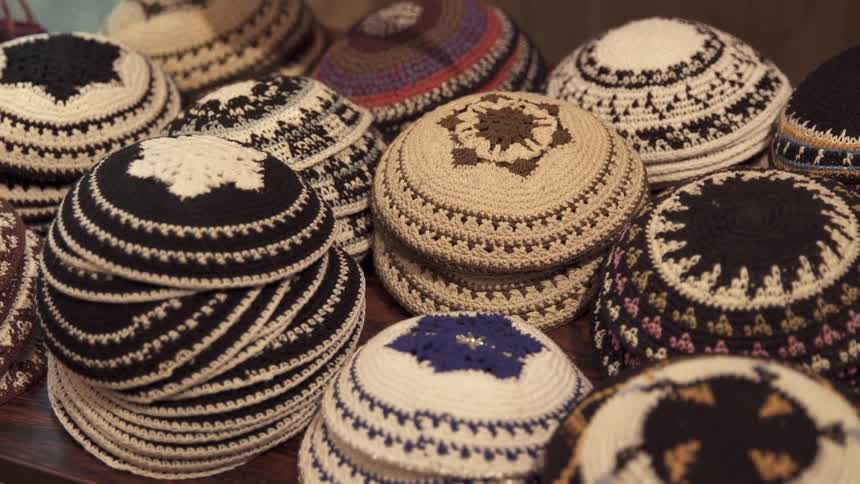 Knitted caps sit stacked on a table