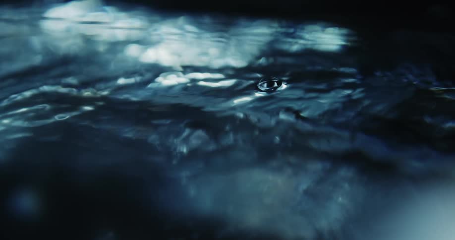 Close up of tiny air bubbles rising to the water surface on a dark environment