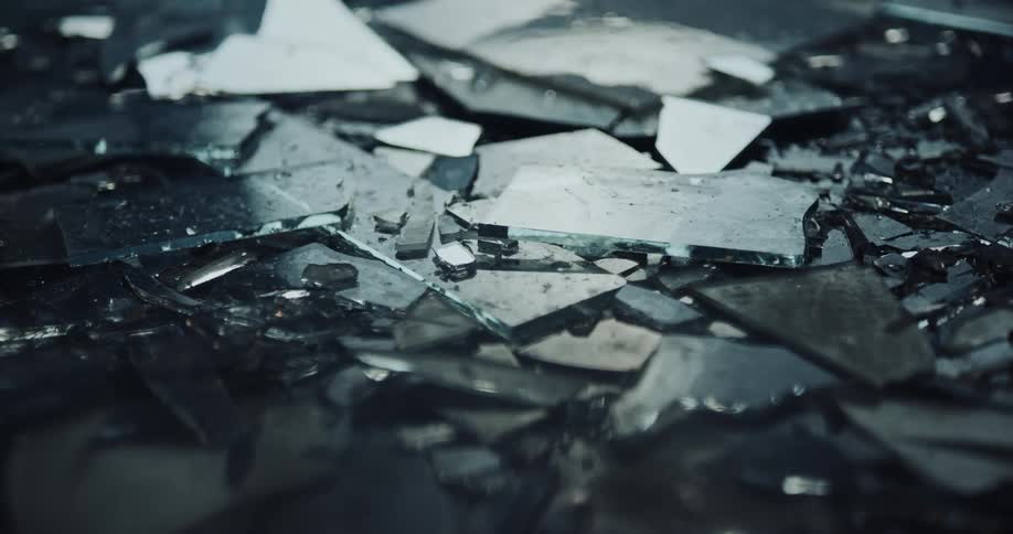 Shards from a broken mirror sit in piles on the ground