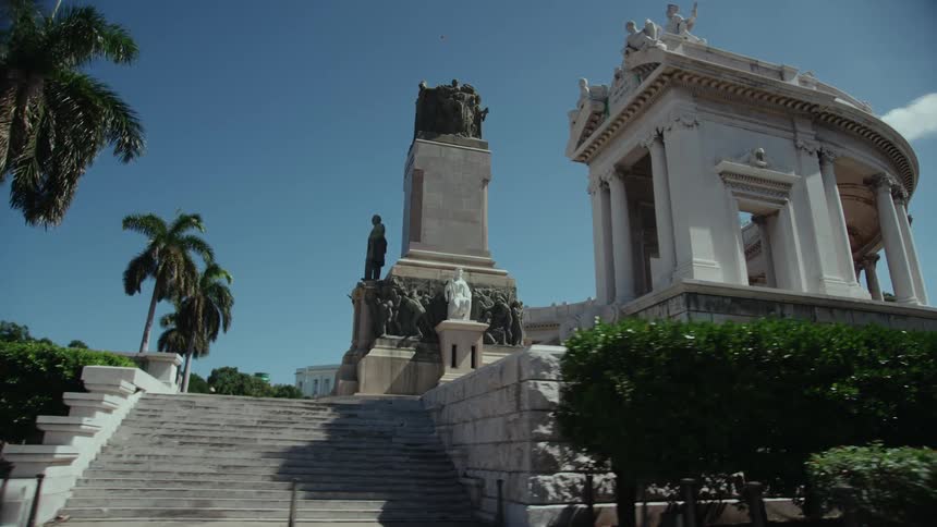 Vehicles travel past a monument