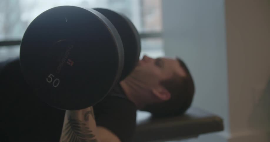 A man lifts weights inside
