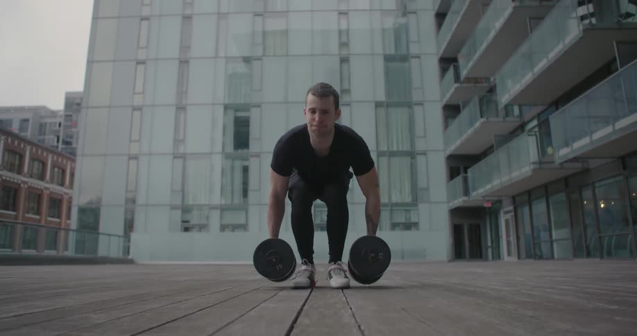 A man lifts weights outside