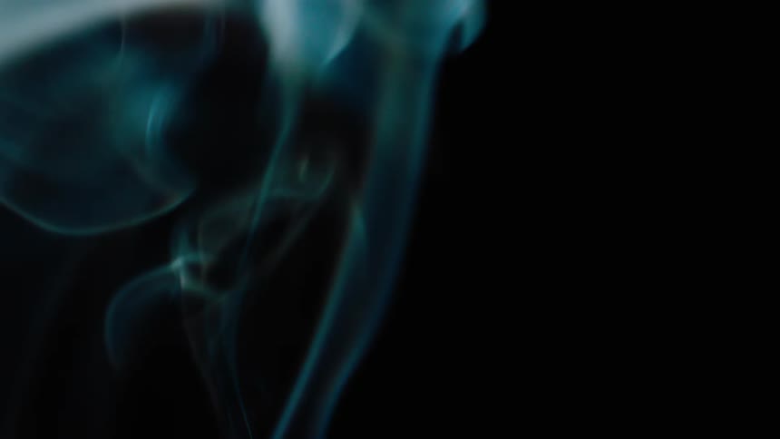 Wisps of smoke twist and turn as they rise in the darkness