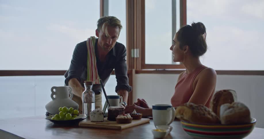 A man is talking to a woman showing her a meal