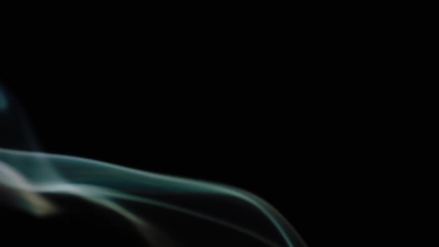 Smoke flowing upwards to the left against complete blackness