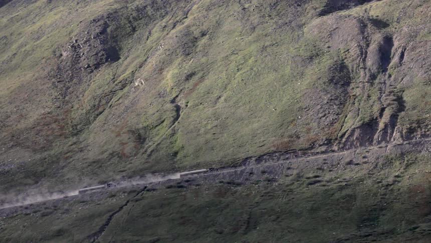 Trucks driving up a steep road