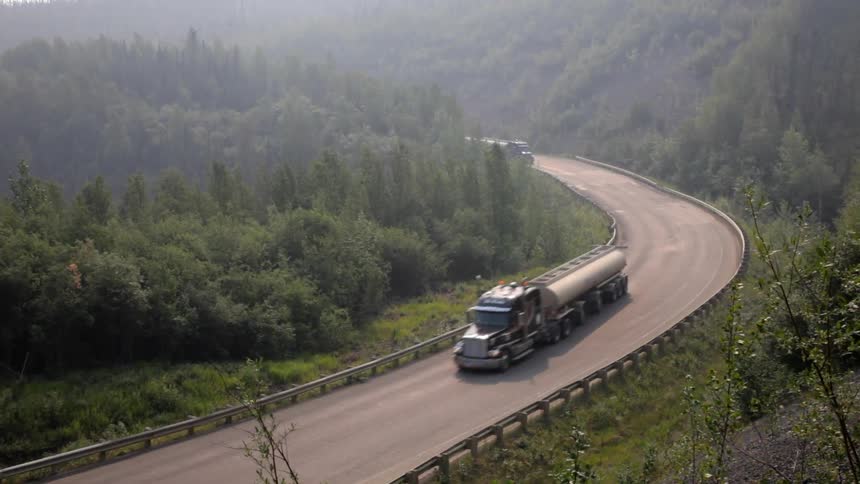 Semi-trucks driving down a road