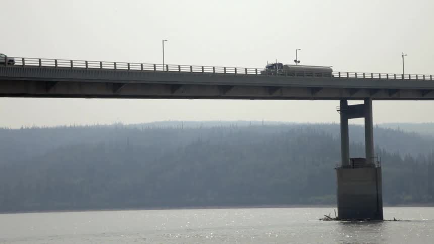 A semi-truck crosses a bridge
