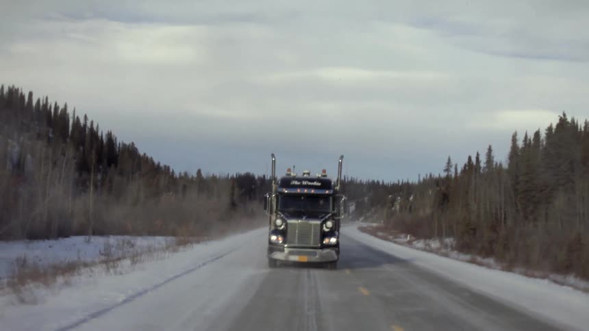 A truck drives down an icy road
