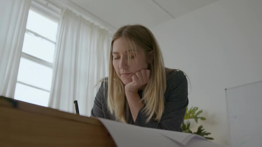 Woman works out solution before moving over to table and writing on plans