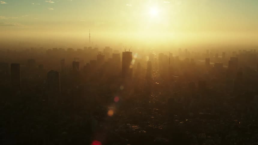 The sun shining down on high rise office buildings in a city skyline