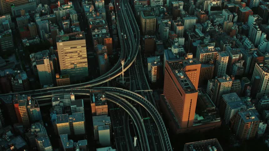 Vehicles drive over a bridge that runs through downtown