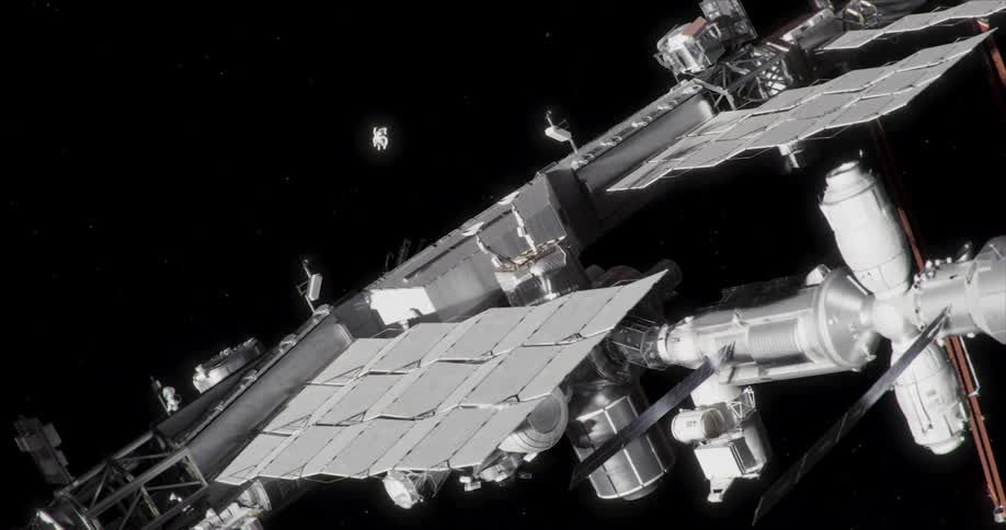 An astronaut in a space suit flies toward the space station