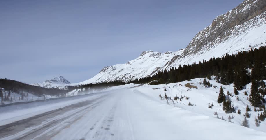 First-person view of traveling along a snowy mountain road