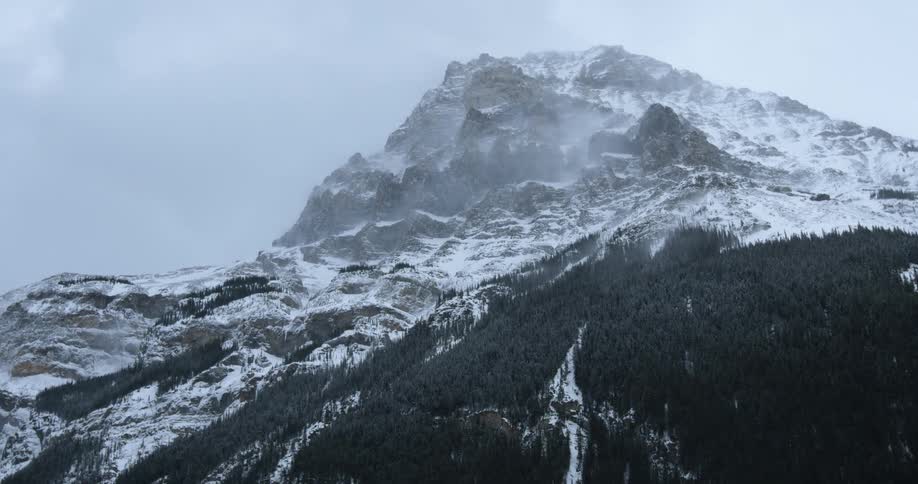 A mountain peak towers overhead during a snowstorm