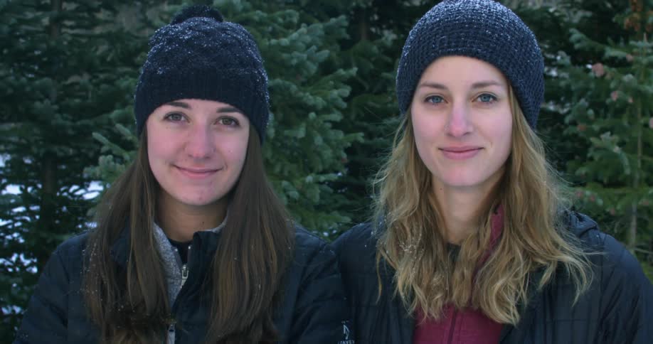 Two women stand side by side smiling