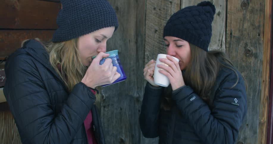 Two women drinking outside