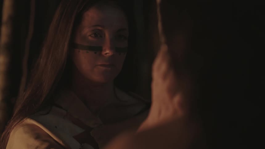 A woman paints on a man's face