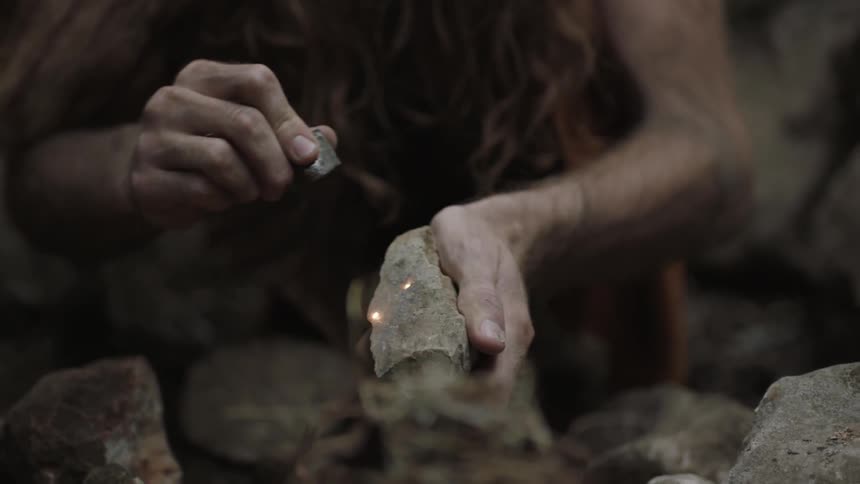 A man strikes two rocks together to create sparks