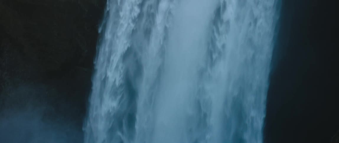 A man walks towards the waterfall