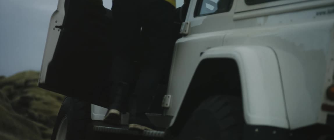 A man is getting into a truck in a rural area