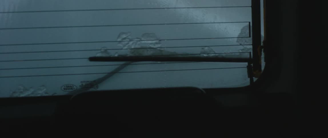 The rain pours on the window of the moving vehicle