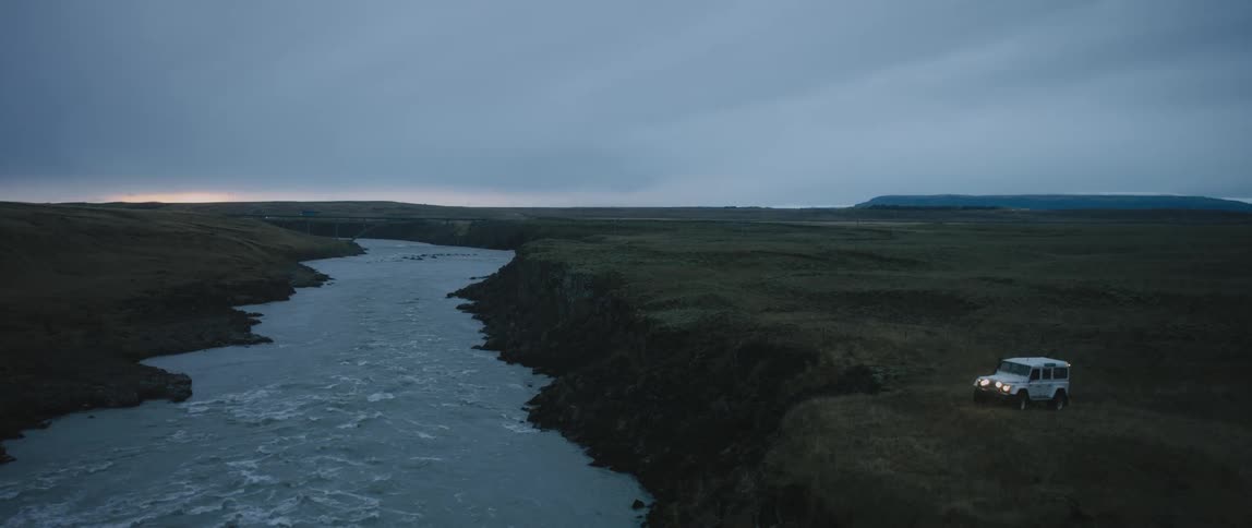 A vehicle is parked by the river