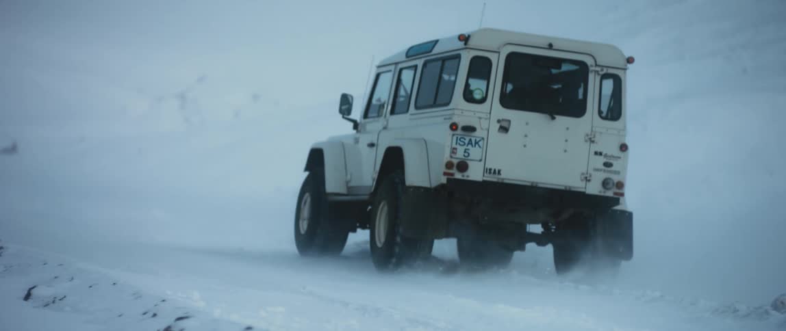 A person is driving a vehicle through an arctic landscape