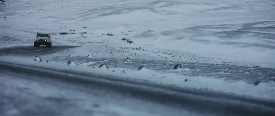 A car is driving in an arctic area during winter