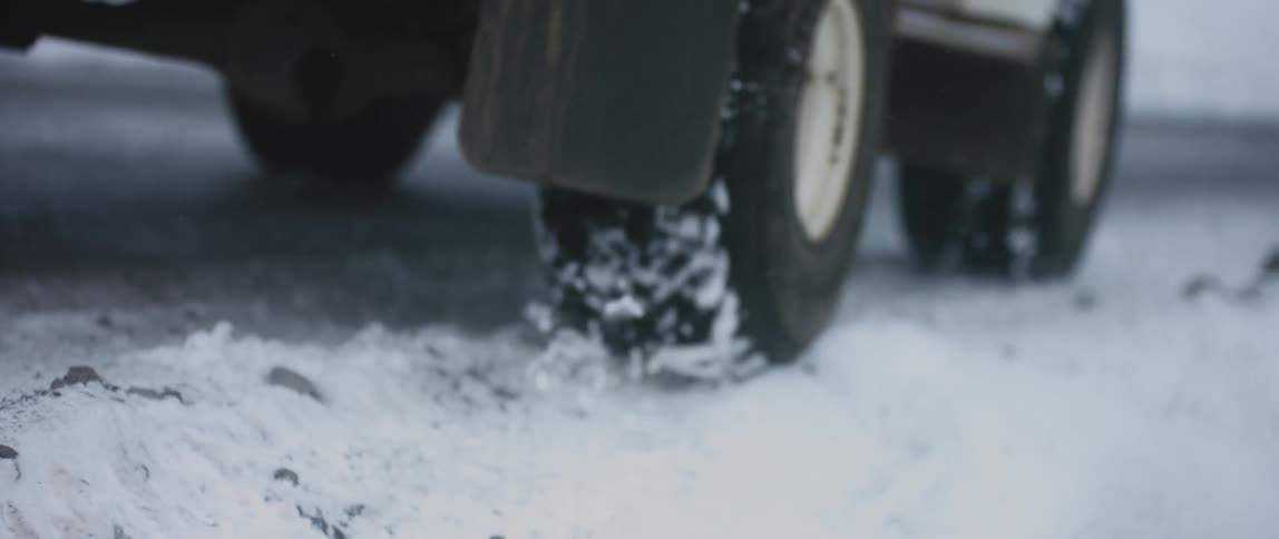 A car drives on the snow covered road