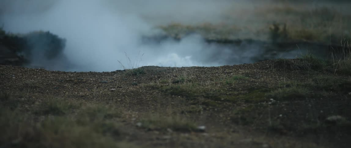 A geyser is erupting with water and smoke
