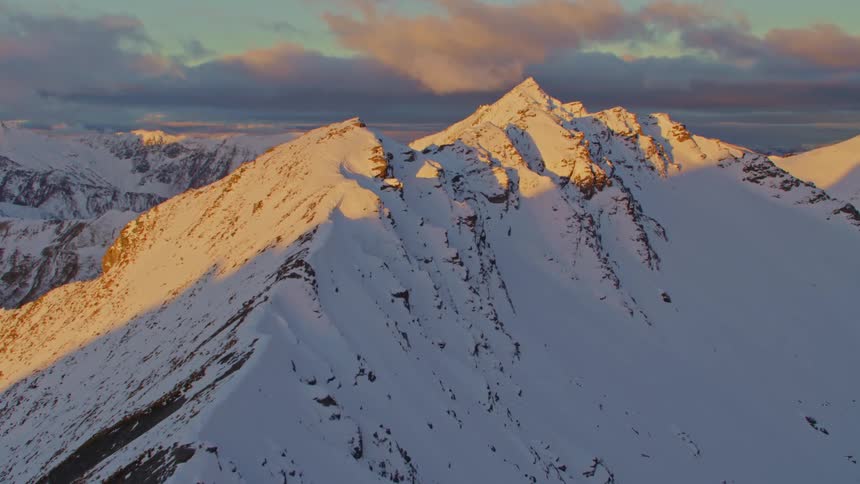An enormous mountain range is completely coated in a layer of thick snow