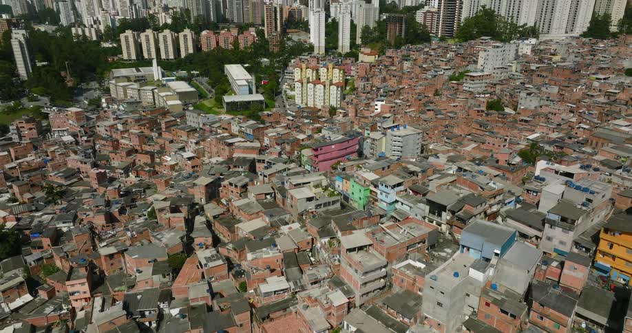 Aerial view of a crowded town with buildings close together and tall buildings and skyscrapers in the distance