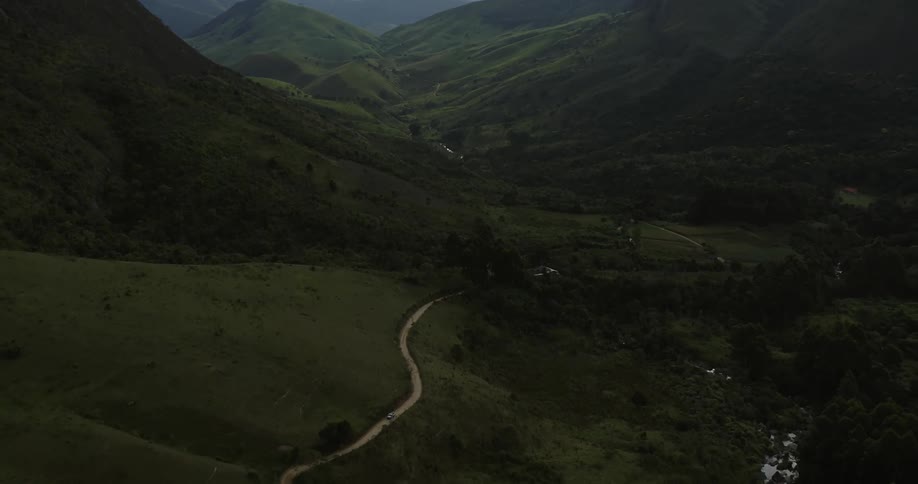 Aerial view of a road on the slopes of a mountain running through a valley on a rural area