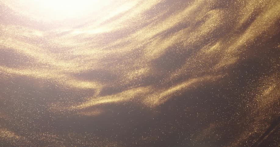 Golden particles of glitter swirl around a bright central light