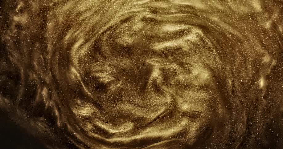 Golden glitter grains spinning and morphing in waves
