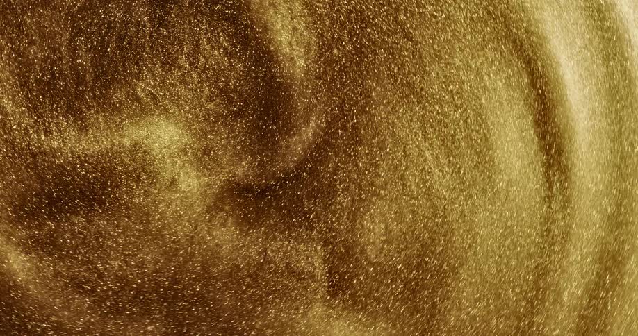 A gold flaky substance is spinning around tightening its rings