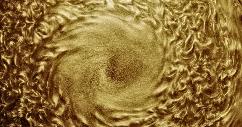 Mixture of gold particles spin and form small raised shapes