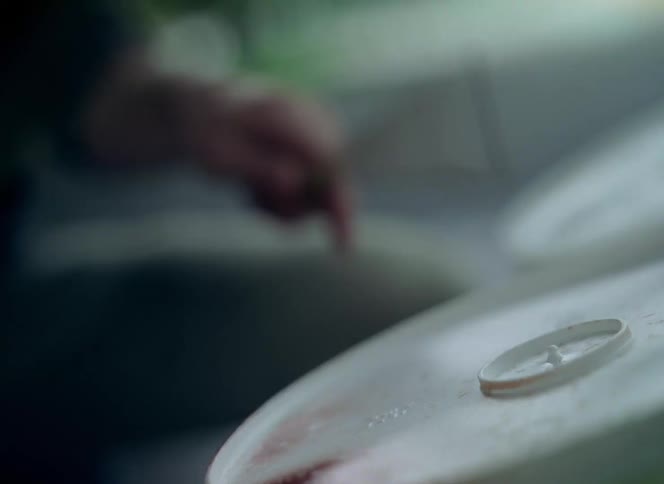 Man uses the back of plastic buckets to play drums energetically