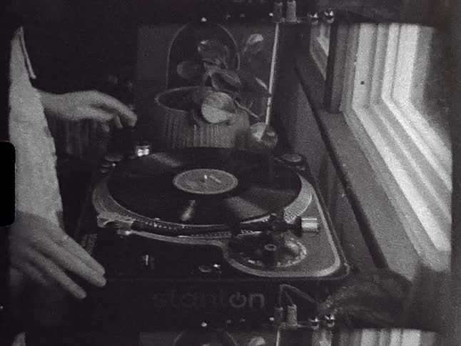 Woman place record on record player near window